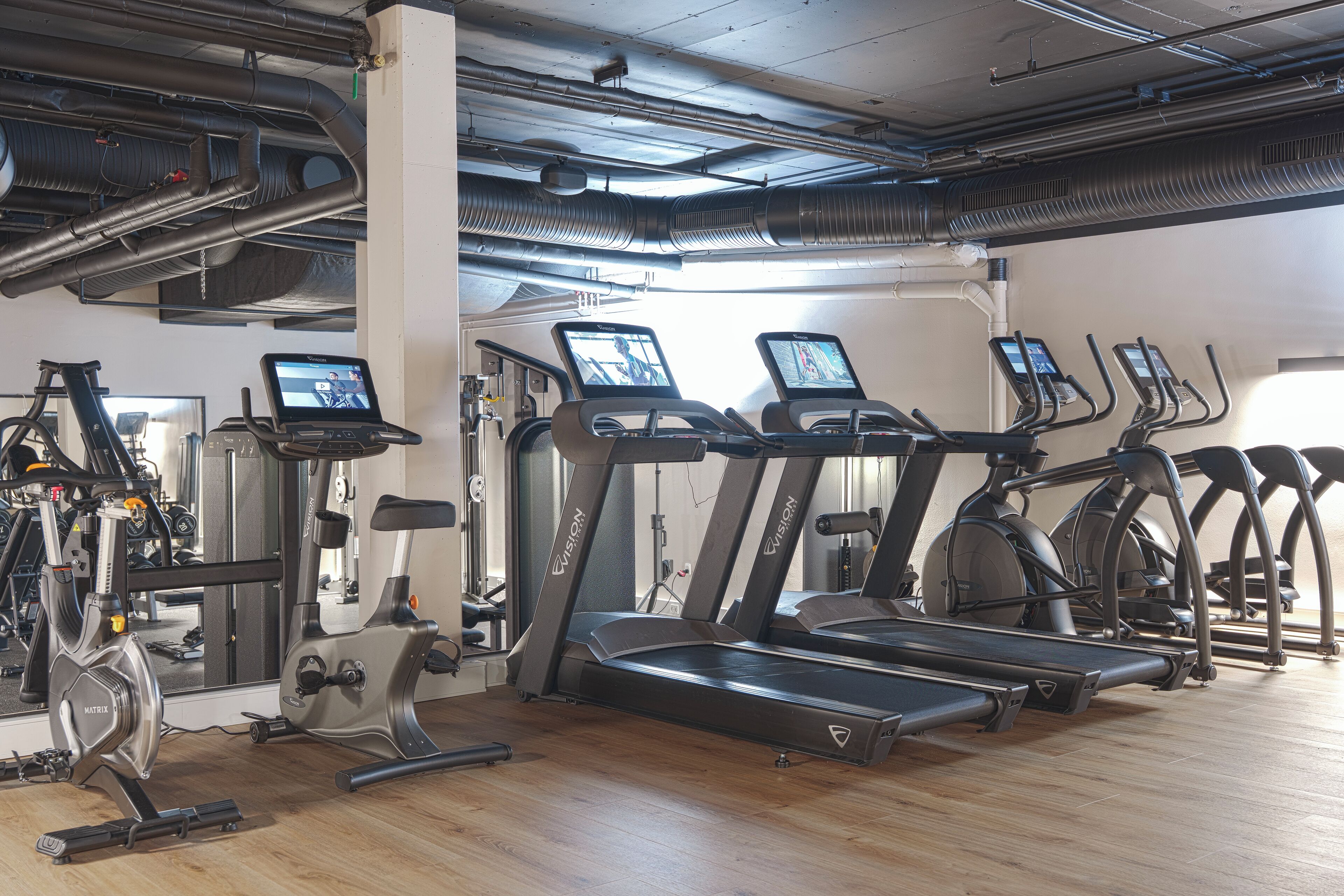 A gym with treadmills, stationary bikes, and weight machines.