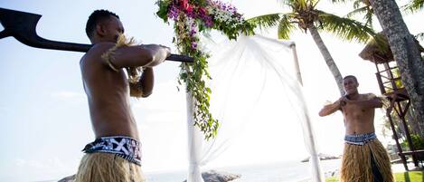 A beachside setting with a decorative arch and palm trees.