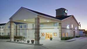 A hotel with a covered entrance, a clear sign, and a number 140 on the facade. - Days Inn by Wyndham Mesquite Rodeo TX (Mesquite)