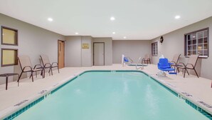 An indoor swimming pool with lounge chairs and a changing room. - Days Inn by Wyndham Mesquite Rodeo TX (Mesquite)