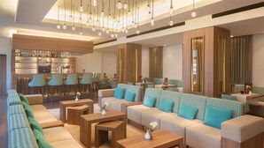 A modern hotel lobby with a bar area, seating arrangements, and a decorative ceiling. - Apartment-Hotel Hamburg Mitte (Hamburg)
