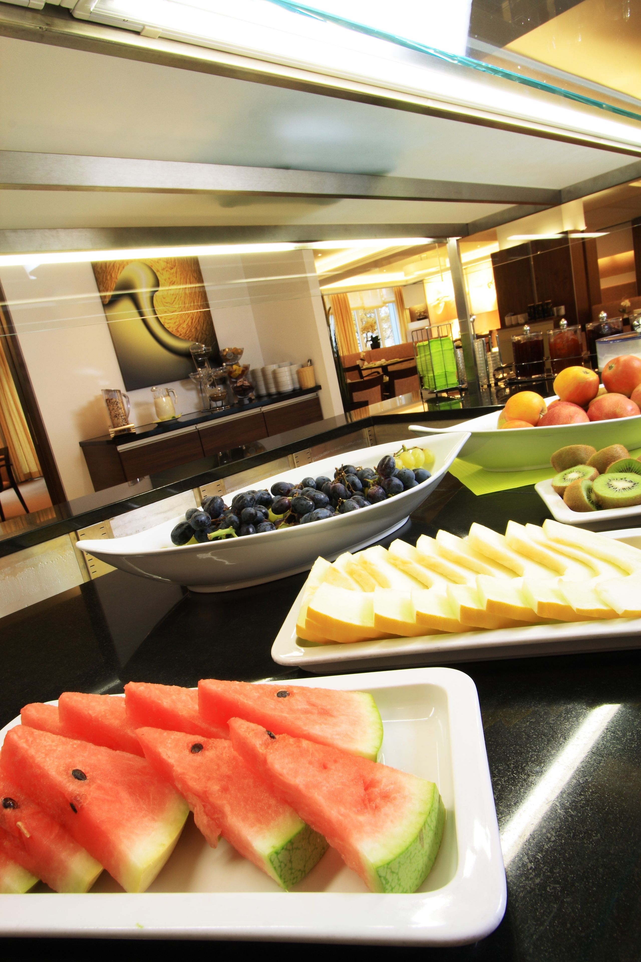 A buffet with various fruits and beverages.