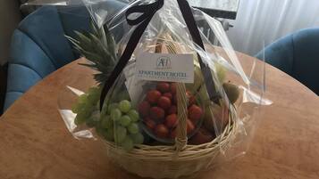 A fruit basket on a table with a label for the apartment hotel.