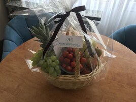 A fruit basket on a table with a label for the apartment hotel.