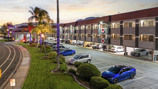 Een hotel met verschillende parkeerlagen en een verzorgd gazon.
