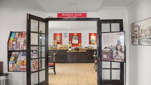 A breakfast room with a counter and a sign indicating it is open from 7:00 am to 10:00 am.