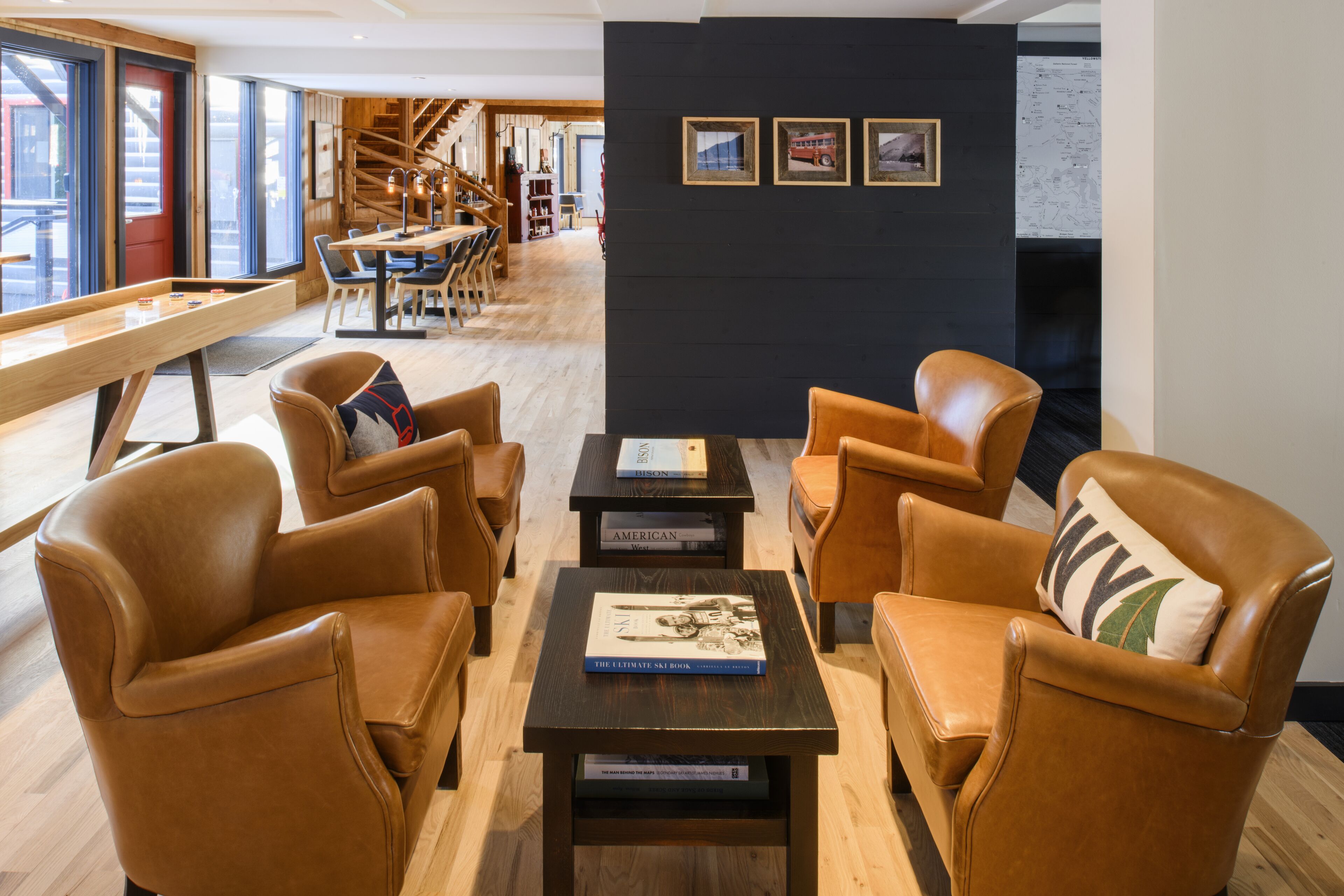 A modern lounge area with leather armchairs, a wooden coffee table, and books.