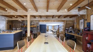A spacious dining area with a long table, wooden chairs, and a central island with a counter. - Mountain Modern Jackson Hole (Jackson)