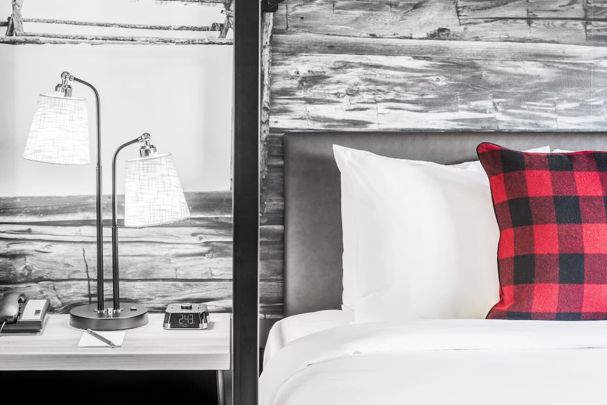 A room with a bunk bed, a desk with a lamp, and a clock.