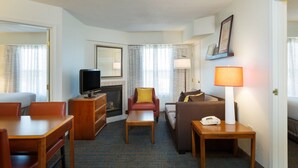A hotel room with a television, a fireplace, a sofa, a chair, a table, and a lamp. - Residence Inn by Marriott Austin Parmer/Tech Ridge (Austin)