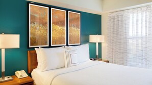 A hotel room with a large bed, two bedside tables, a phone, and artwork on the wall. - Residence Inn by Marriott Austin Parmer/Tech Ridge (Austin)