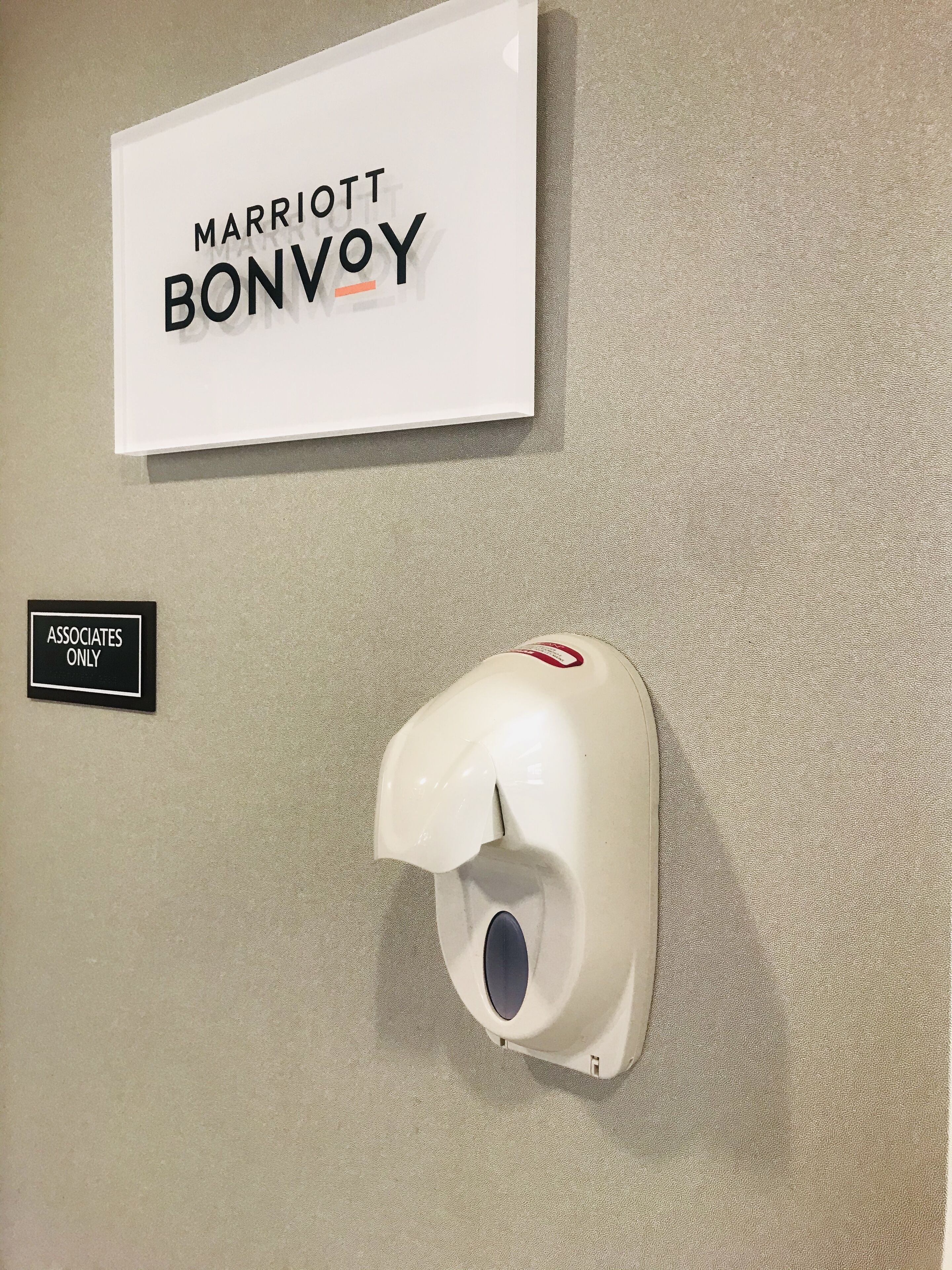 Señalización de 'Marriott Bonvoy' y un letrero que dice 'Solo personal autorizado', junto con un dispensador de gel antibacterial.
