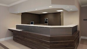 Un comptoir d’accueil au design moderne, doté d’un revêtement en bois et d’un plateau supérieur plat.