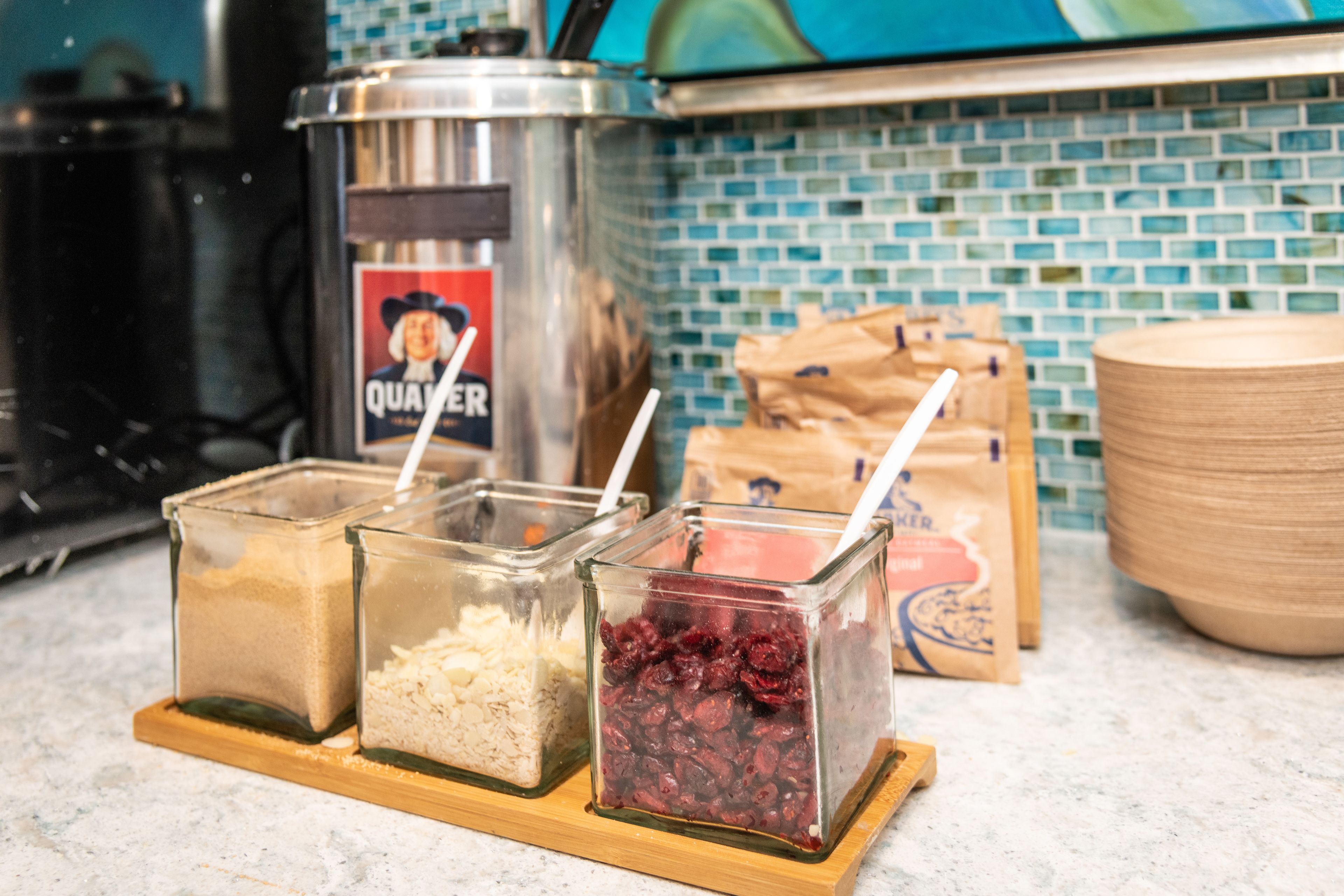 Tres recipientes de vidrio con diferentes alimentos sobre una tabla de madera.