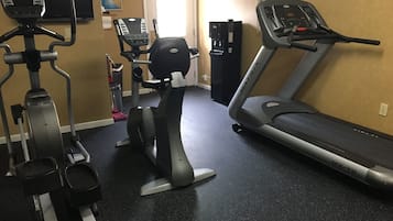 A home gym with a treadmill, elliptical, and stationary bike.
