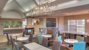 A hotel lobby with a reception desk, seating areas, a fireplace, and a large TV screen. - Residence Inn by Marriott McAllen (McAllen)