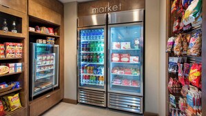 A grocery store with refrigerated freezers stocked with beverages and snacks, and shelves with packaged goods. - Residence Inn By Marriott Louisville Northeast (Louisville)