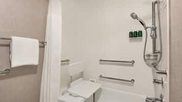A modern bathroom with a shower, grab bars, and a white towel rack.