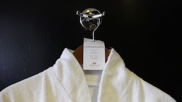 Un asciugamano bianco appeso a un gancio in metallo con un'etichetta che recita "Lisamukavuutta För Er Komfort For Your Comfort Crowne Plaza Hotels & Resorts".