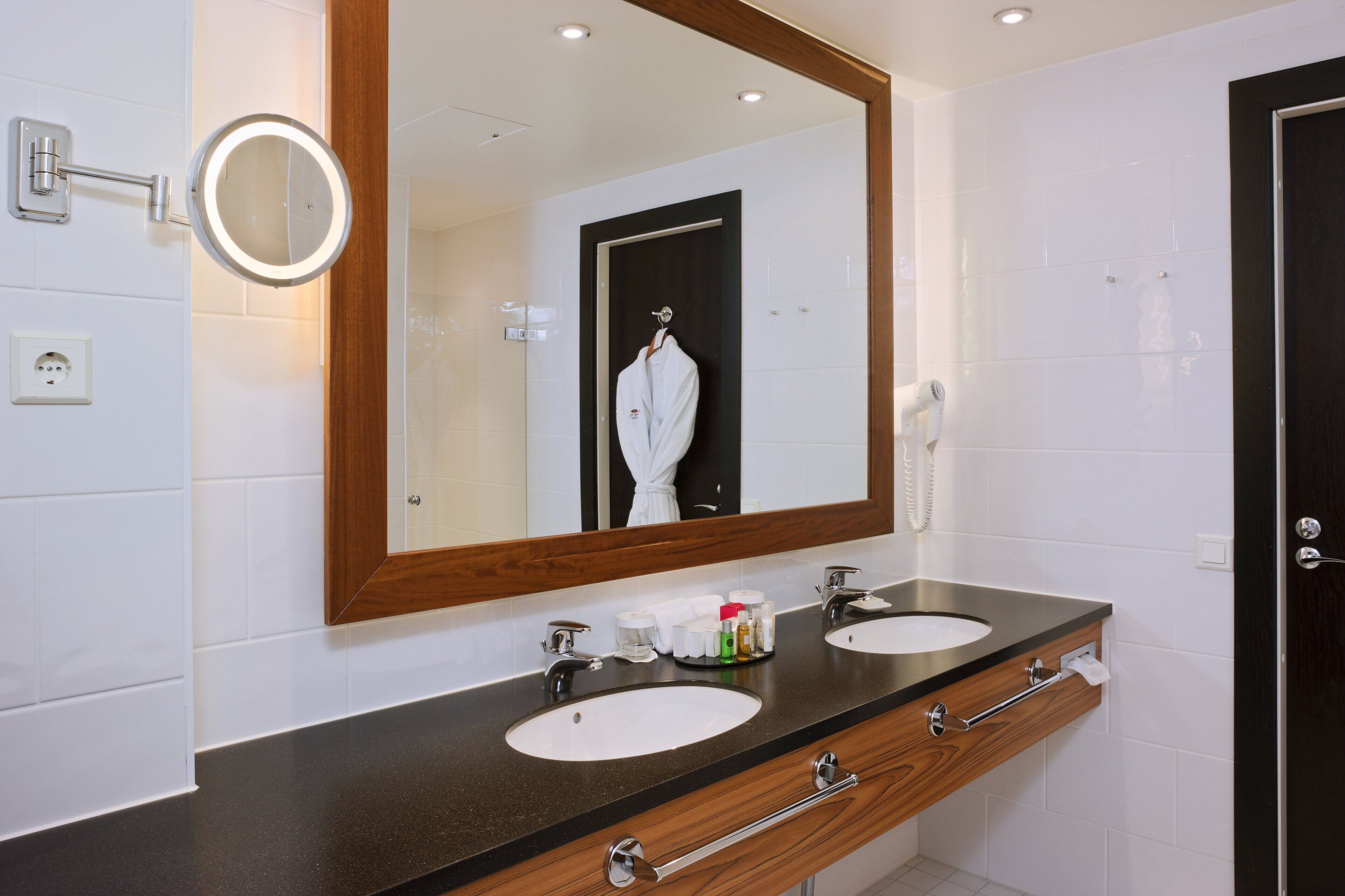 A bathroom with two sinks, a mirror, and a towel rack.