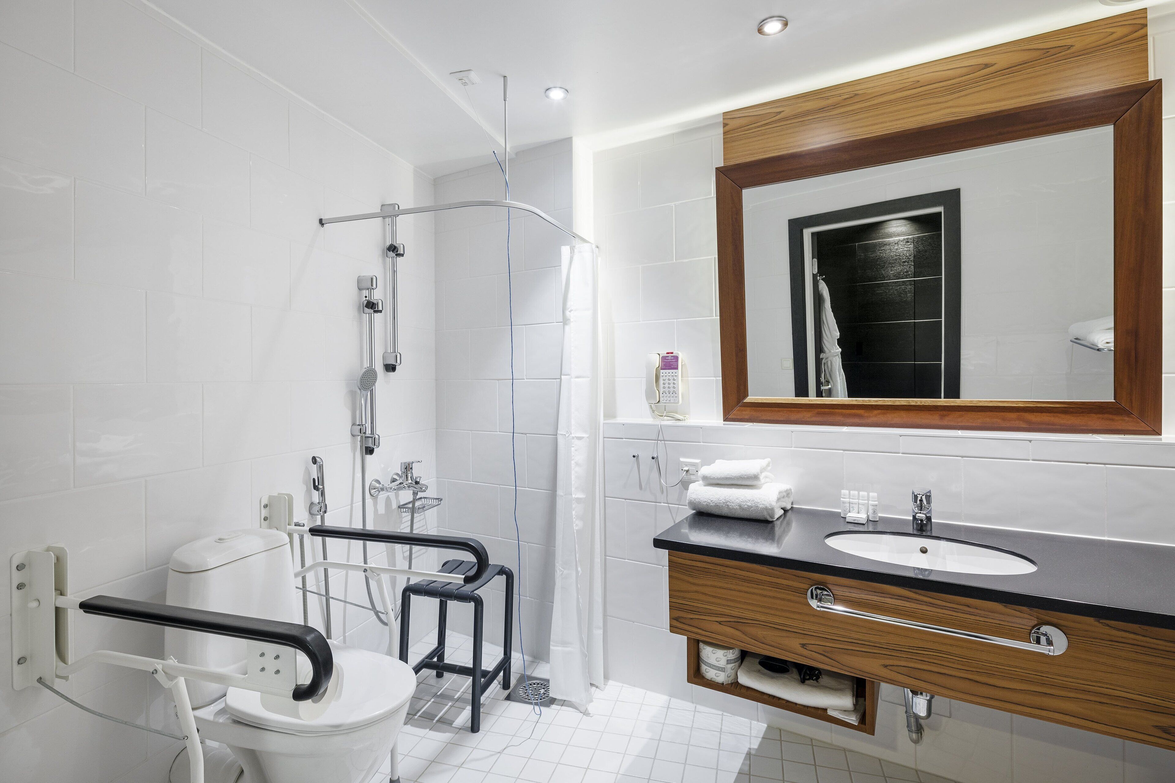 A modern bathroom with a shower, toilet, and vanity.