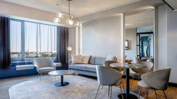 Una sala moderna con un sofá, sillones, una mesa de centro y una mesa de comedor.