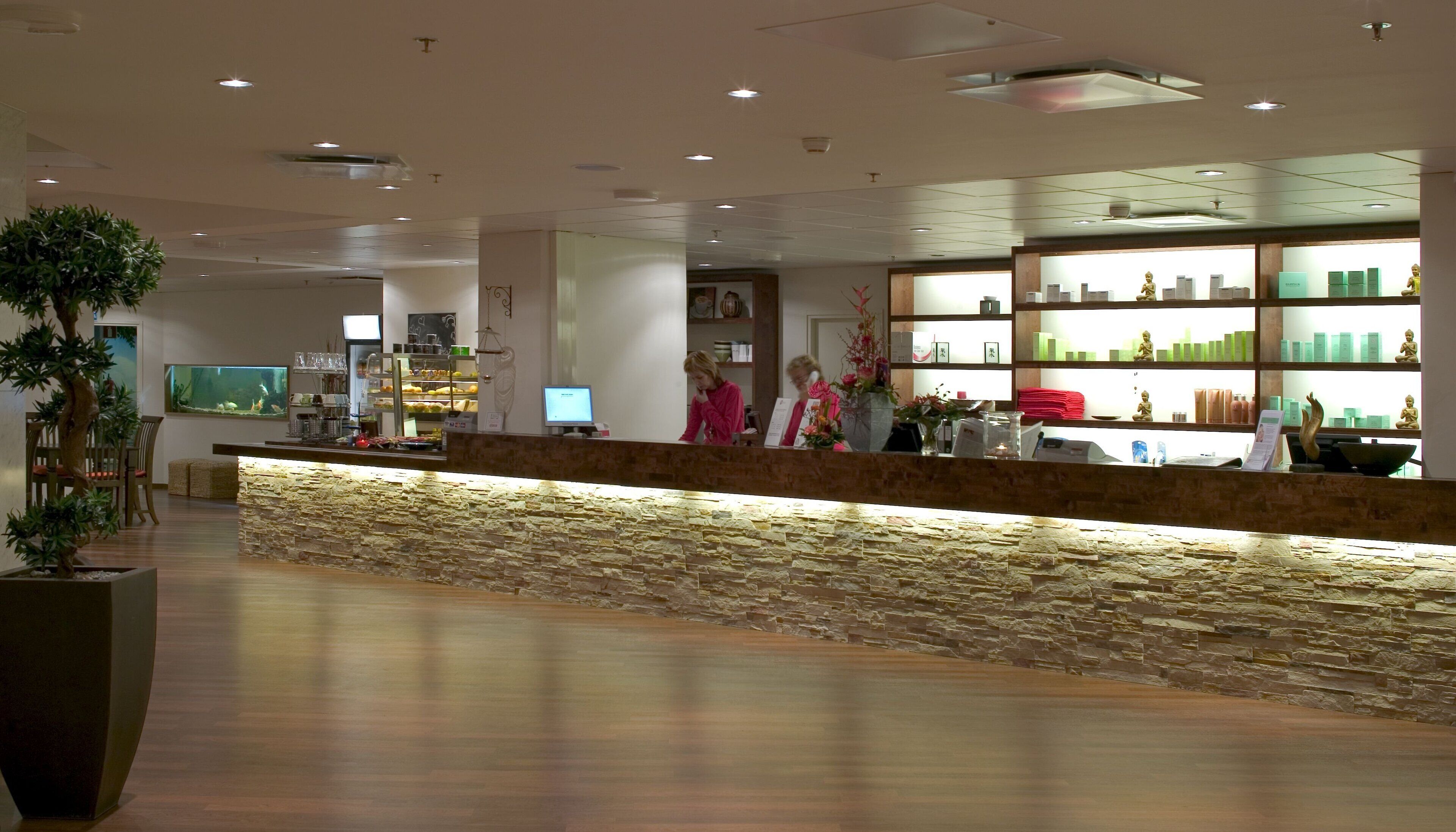 A reception area with a stone counter, a fish tank, and a display of products.