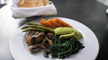 A plate of food with mushrooms, asparagus, spinach, and avocado on a white plate.