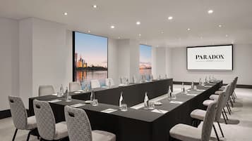 Une salle de conférence avec une longue table, des chaises et une vue sur la ville.