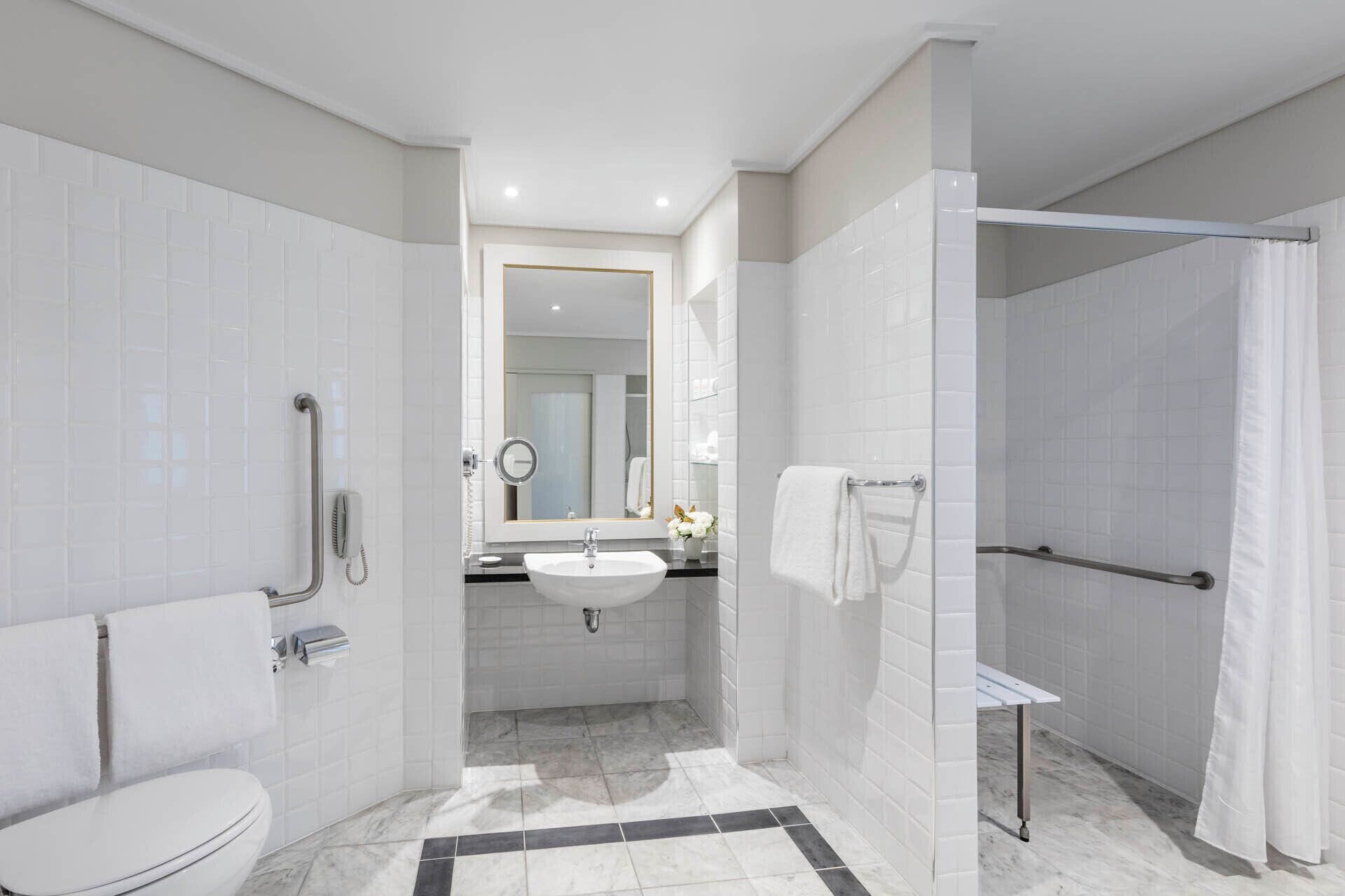 A modern bathroom with a toilet, sink, and shower.