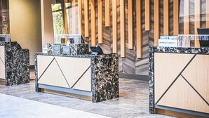 A reception desk with a modern design, featuring a marble top and wooden accents. - Delta Hotels by Marriott Cincinnati Sharonville (Sharonville)