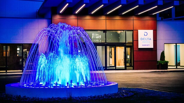 A modern hotel entrance with a prominent fountain and a sign for Delta Hotels Marriott. - Delta Hotels by Marriott Cincinnati Sharonville (Sharonville)