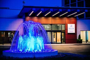 Une entrée d’hôtel moderne, agrémentée d’une fontaine imposante et d’une enseigne indiquant « Delta Hotels Marriott ».