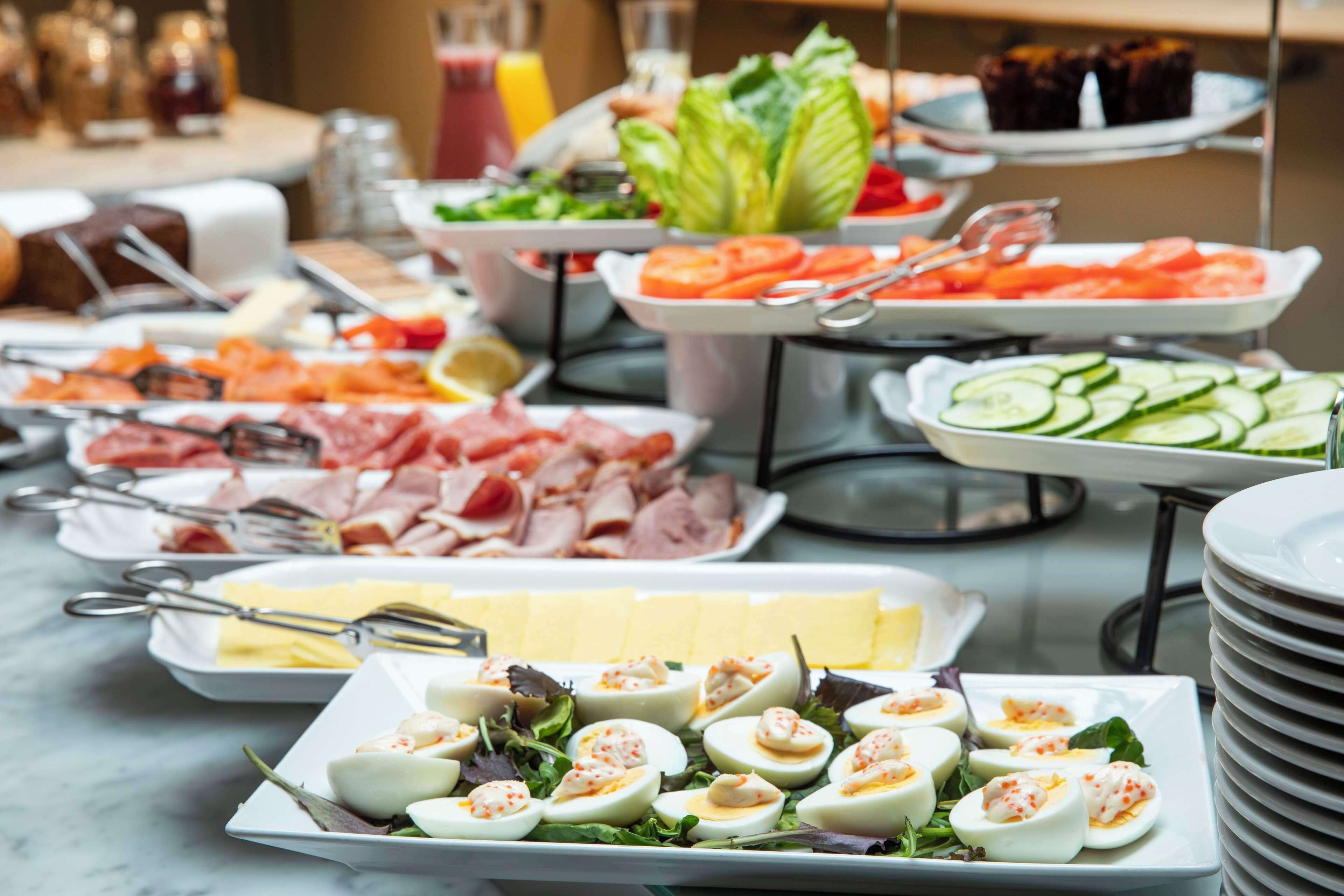 Un bufé con diversas opciones de comida, incluyendo carnes, quesos y ensaladas.