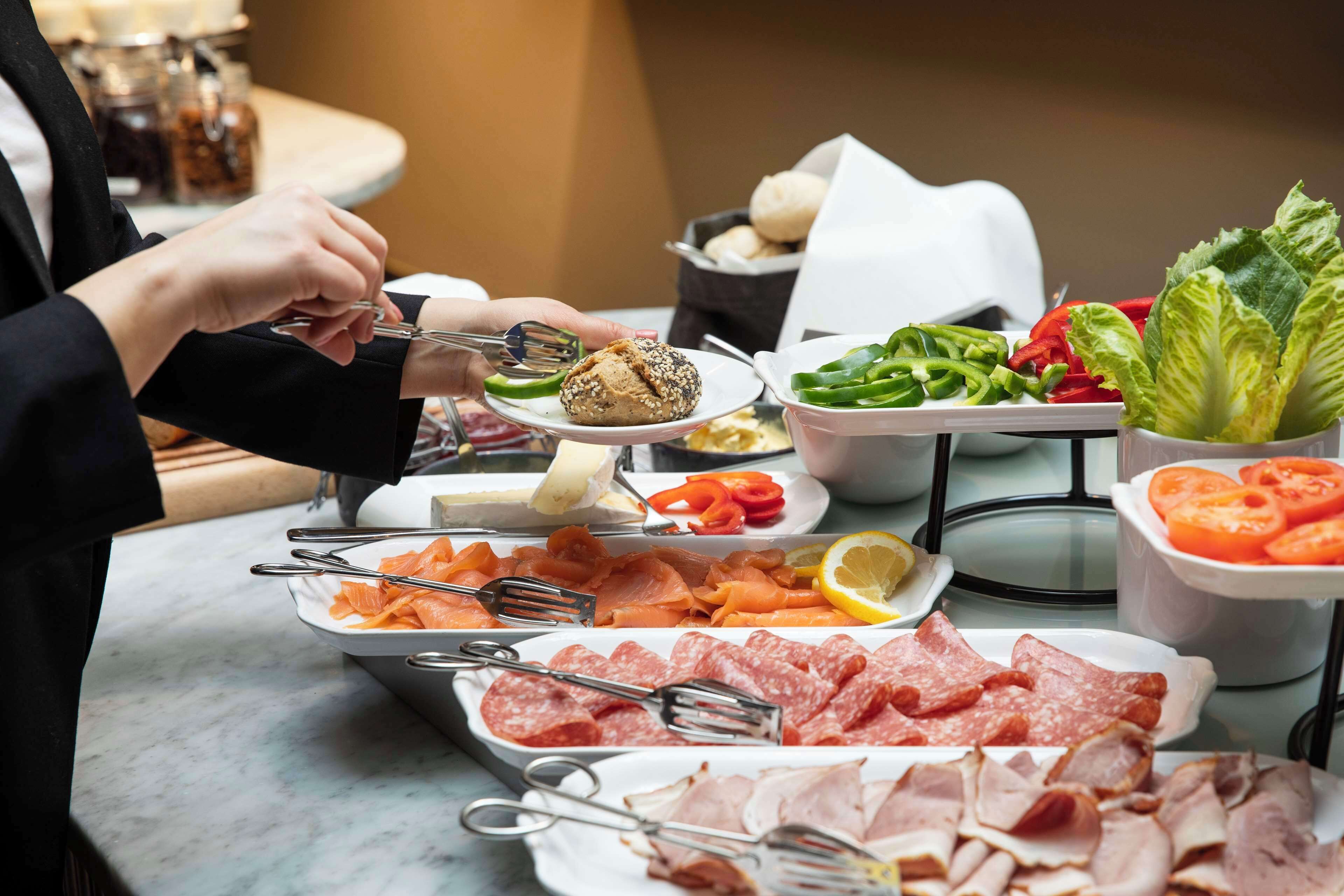 Ein Buffet mit verschiedenen Speisen, darunter Fleisch, Gemüse und Salat.