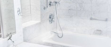 A modern bathroom with a bathtub, a shower with a handheld showerhead, and a grab bar.