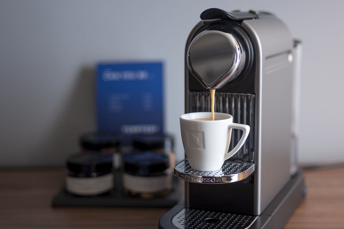 Una cafetera sirviendo café en una taza.