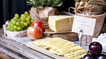 A cheese board with various cheeses, grapes, and an apple.
