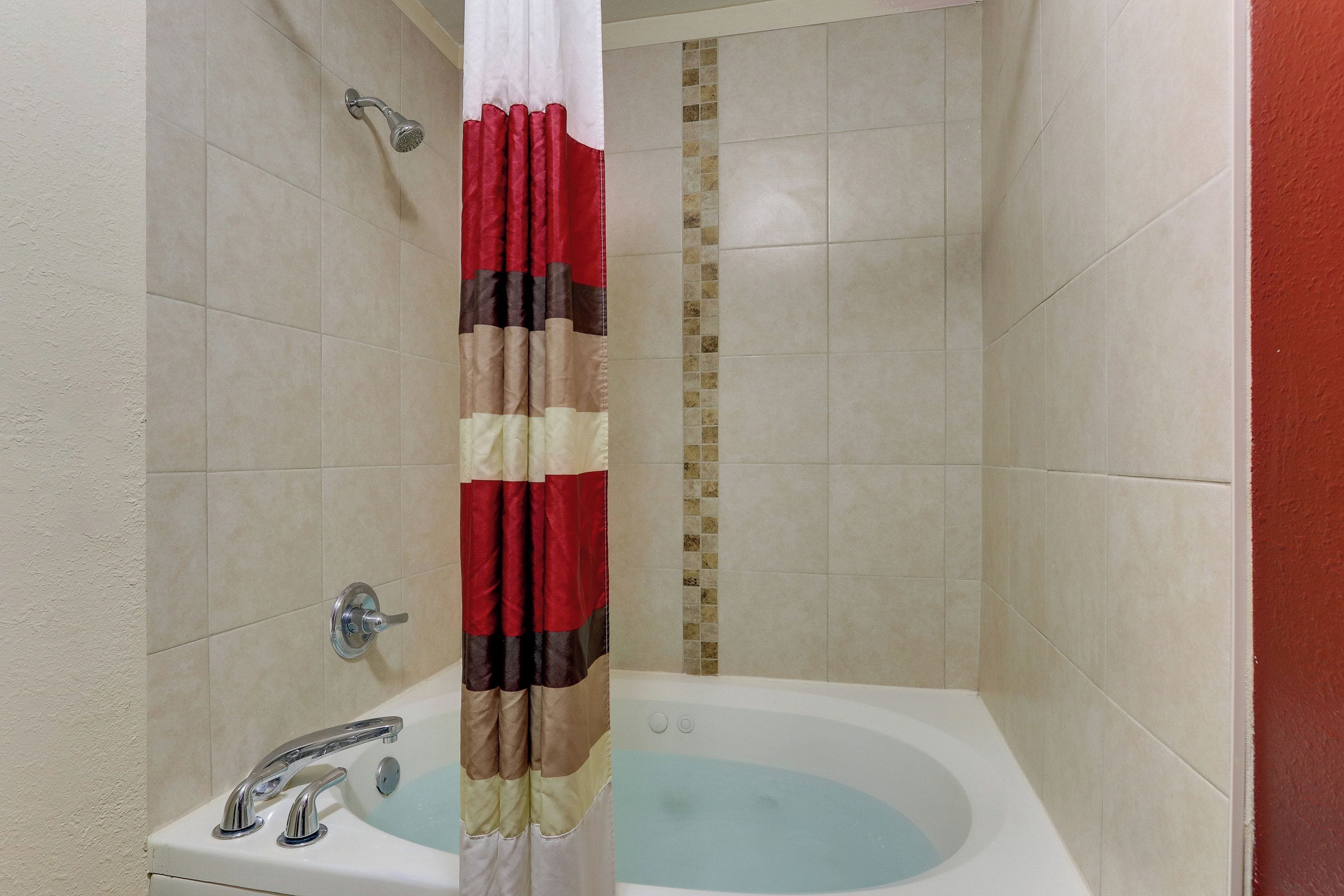 A bathroom with a shower, a sink, and a bathtub.