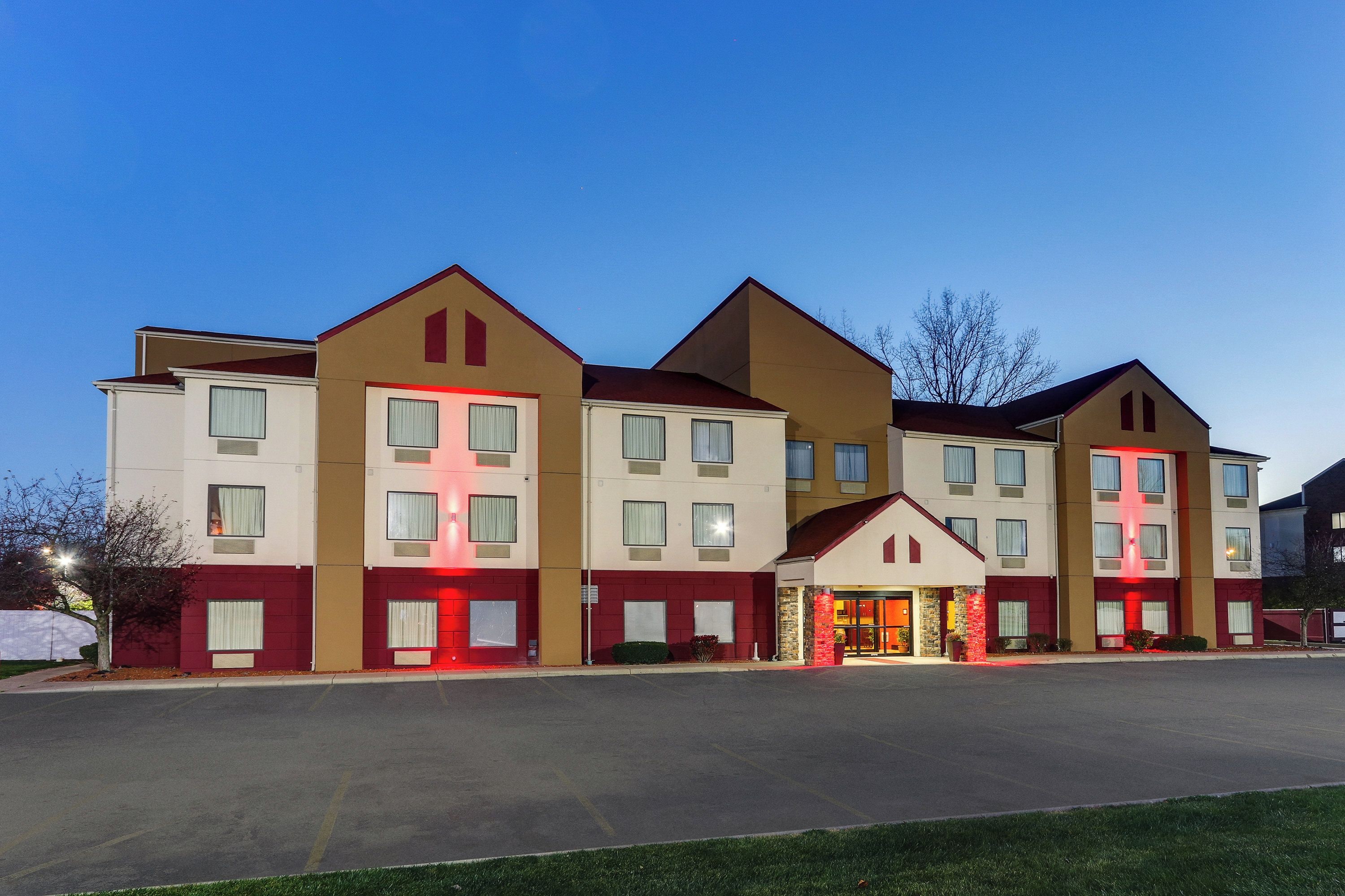 A multi-story hotel with a central entrance and individual units on either side.