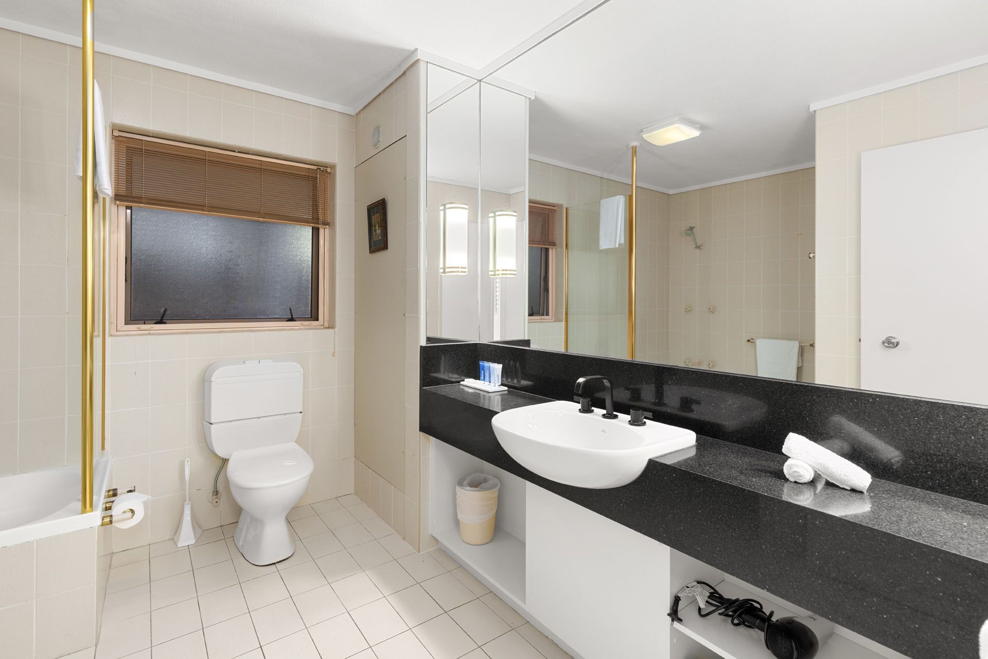 Een moderne badkamer met toilet, wastafel en douche.