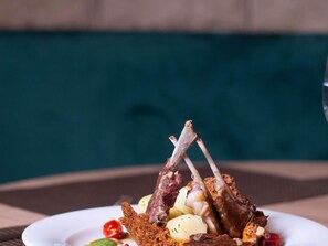 A plate with roasted lamb chops, potatoes, and cherry tomatoes. - Hotel Mercure Rabat Sheherazade (Rabat)