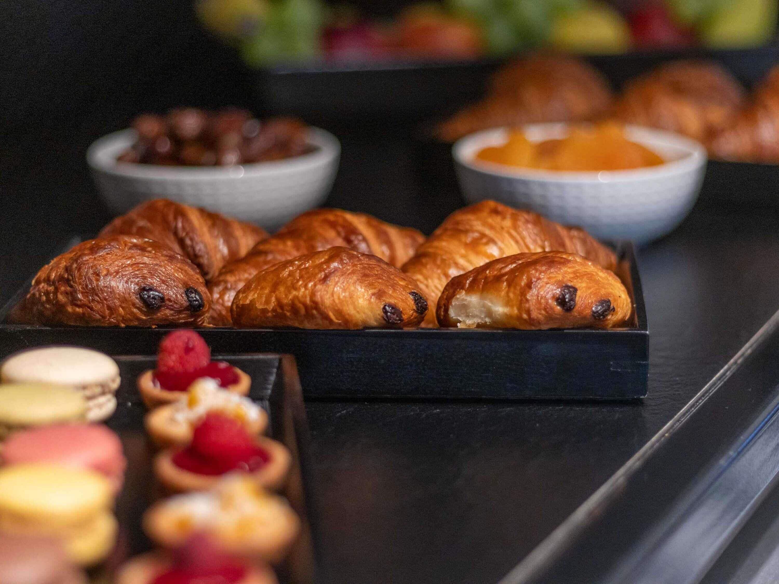 A tray of croissants and assorted pastries on a table.