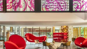 A modern lobby with red chairs, a red sofa, and a round table. - Mercure Paris Centre Tour Eiffel (Paris)