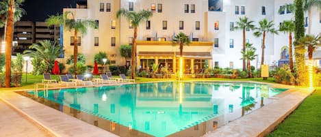 Una piscina al aire libre, sombrillas