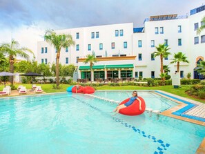 Una piscina al aire libre, sombrillas