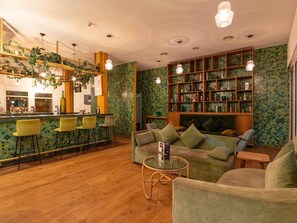 Una zona de bar con taburetes, un sofá y una mesa de vidrio.