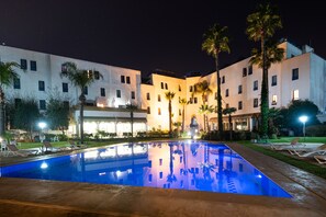 Una piscina al aire libre, sombrillas