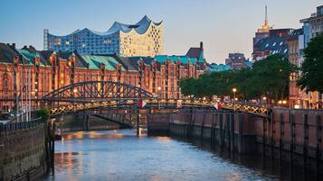 A historic bridge over a river with a modern building in the background.