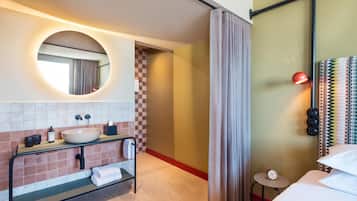 Un baño moderno con un espejo redondo, un lavabo y un perchero para toallas.